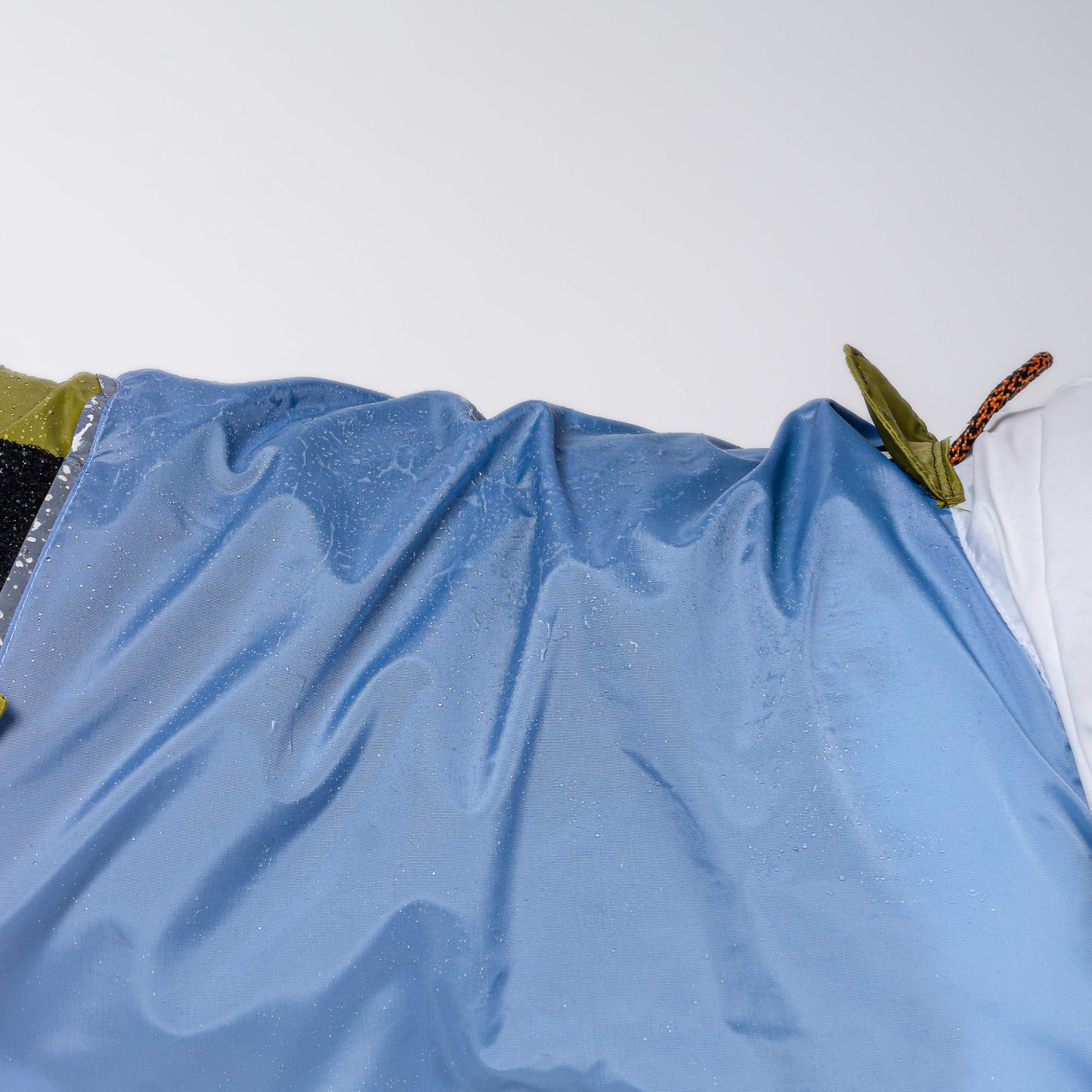 Ropa para perro. Impermeable verde, azul y blanco en perro de raza grande. Tallas van desde Chihuahua hasta pastor alemán. Foto enseña el bies de reflejante y la tela repelente de agua.