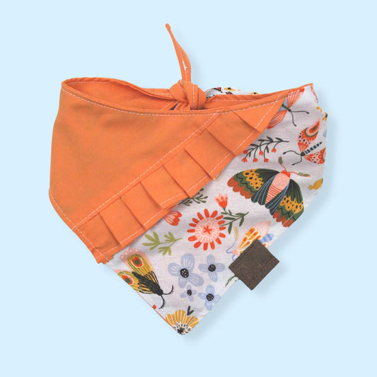 Bandana para perro con estampado de flores e insectos y olan naranja.