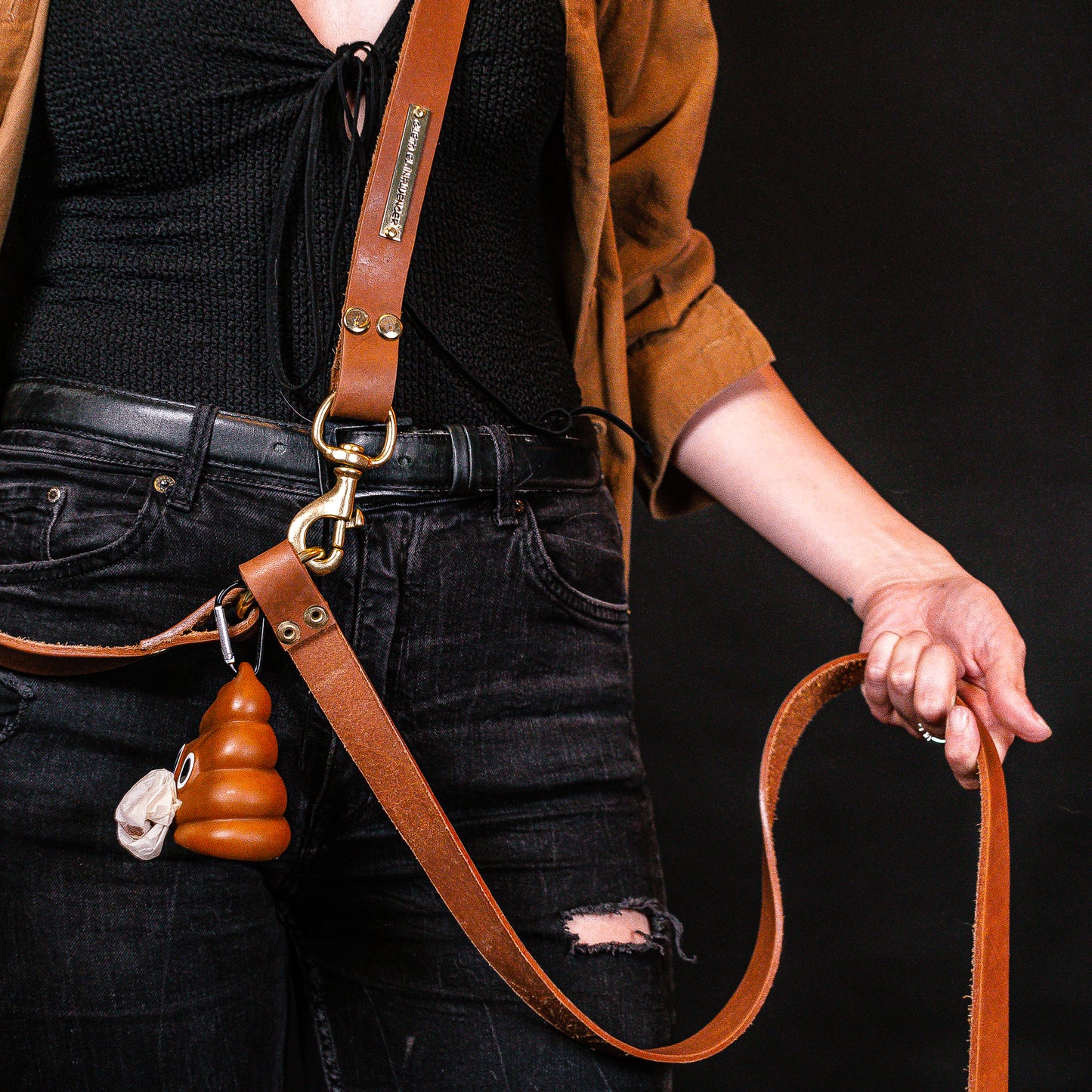 Zoom in to hands free leash in female model´s torso, which shows a bag dispenser with bags.